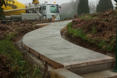 Allée en béton désactivé bordée de pavés